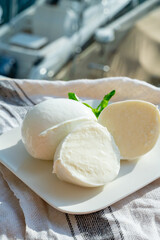 Tasting of white soft italian balls mozzarella cheese made from buffalo cow milk