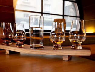 Flight of single malt scotch whisky in glasses served in whiskey bar in Edinburgh, UK