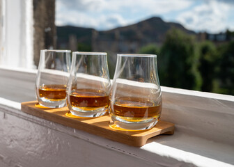Flight of single malt scotch whisky served on old window sill in Scottisch house with view on old part of Edinburgh, Scotland, UK