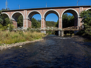 Old train bridge in a valley in the Belgian Ardennes at the river Ambleve