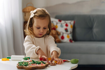 A little girl playing with play dough and Christmas decorations. Child hands creating Christmas crafts. Holiday Art Activity for Kids. Sensory play for toddlers.