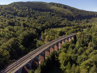 Old train bridge in a valley in the Belgian Ardennes at the river Ambleve