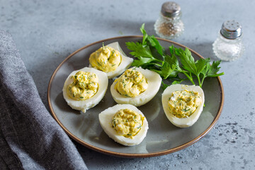 Step-by-step preparation of an egg snack with red fish with a carrot decoration, step 4 - placing the filling in the halves of the eggs, selective focus