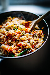 cooking tasty rice and vegetable mix with corn, pea, beans in pan on kitchen