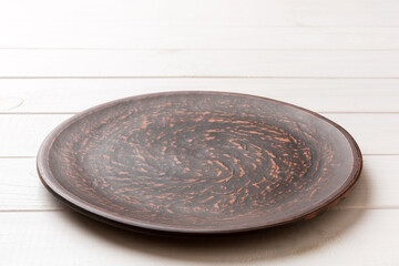 Perspective view of empty plate on wooden background. Empty space for your design
