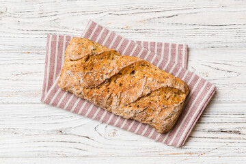 Fresh loaves of bread with wheat and gluten on a colored table. bread on napkin on rustic background, fresh bread top view