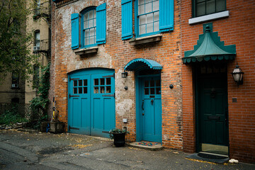 Fototapeta na wymiar Beautiful brick house with blue doors, on Hunts Lane in Brooklyn Heights, Brooklyn, New York