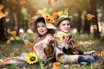 Children in autumn costumes are playing in the park