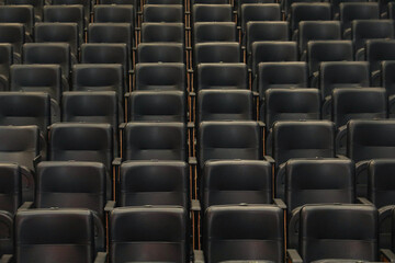 Naklejka premium Theater auditorium with emphasis on the black chairs and wooden sides, all the same giving continuity and lines.