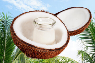 Coconut milk and halved old coconuts on a wooden table