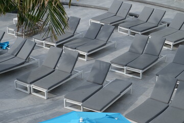 Gray sunbeds by the sea for tourists