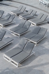 Gray sunbeds by the sea for tourists