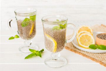 Healthy breakfast or morning with chia seeds lemon and mint on table background, vegetarian food, diet and health concept. Chia pudding with lemon and mint