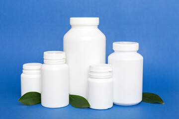 supplement pills with medicine bottle health care and medical top view. Vitamin tablets. Top view mockup bottle for pills and vitamins with green leaves, natural organic bio supplement, copy space