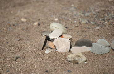 Fototapeta na wymiar Pyramid of stones on a pebble sea beach.