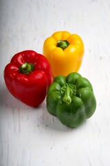 yellow,red,green sweet bell pepper or capsicum isolated on white wooden background.top view