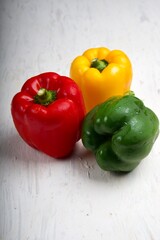 yellow,red,green sweet bell pepper or capsicum isolated on white wooden background.