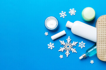 Christmas flat lay with makeup cosmetic products in cosmetic bag on colored background. Top view New year Beauty concept