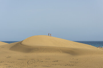 People walking on Maspalomas dunes during summer season in Maspalomas, Gran Canaria, Spain