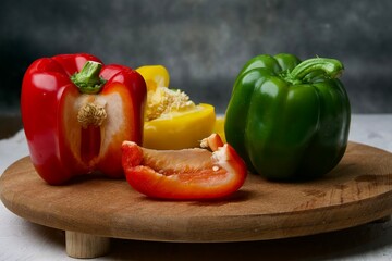 set of fresh whole and sliced red and yellow sweet bell pepper on wooden board.eye level view.