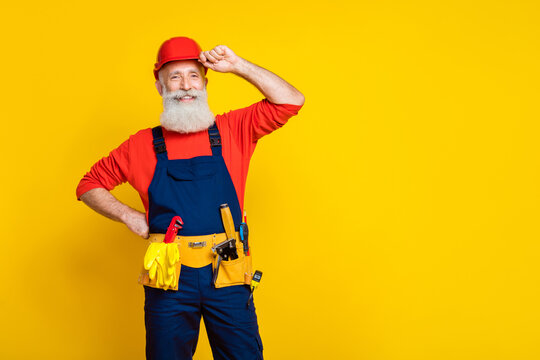 Photo portrait of nice grandpa craftsman arm touch helmet cheerful professional dressed safety uniform isolated on yellow color background