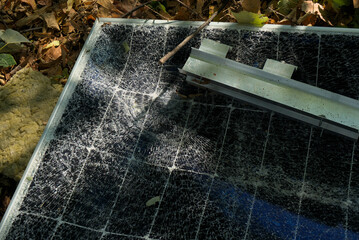 A broken solar panel, a torn panel mount lie on the ground. Consequences of a natural disaster....