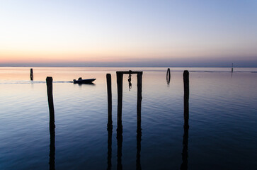 Un motoscafo naviga veloce nella laguna di Venezia, a Pellestrina, al crepudscolo