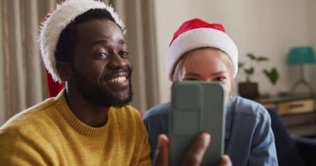 Happy group of diverse friends using smartphone for video call at christmas party - Powered by Adobe