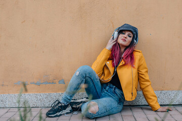 trendy redhead urban girl on the street with headphones