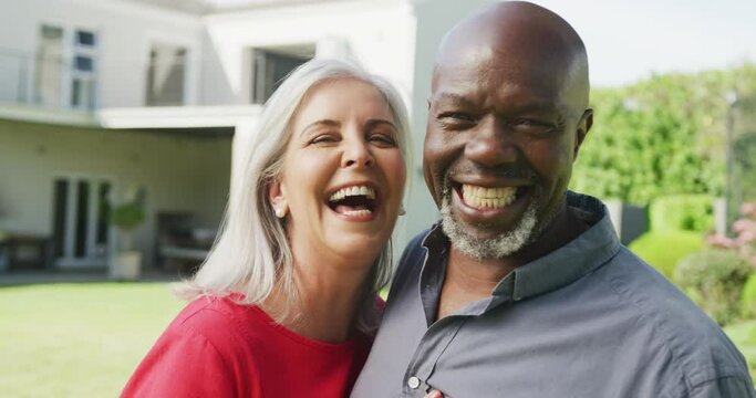 Portrait of happy senior diverse couple in garden