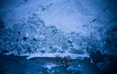 Aerial top view from above of frozen sea glaciers at the beach. Cracked ice floes in ocean on...