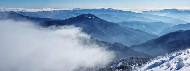 Beautiful sunny winter landscape in thу mountains. Mountain and fir trees covered with snow and...