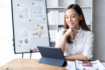 Beautiful Asian business woman working at the office With tablet.