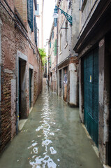 Una calle di Venezia invasa dall'acqua alta in una giornata nuvolosa di novembre