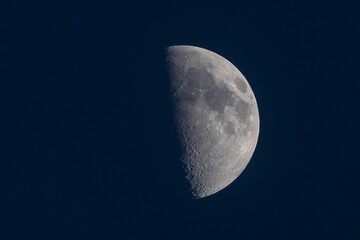 Close shot of the gey half moon in a dark blue background