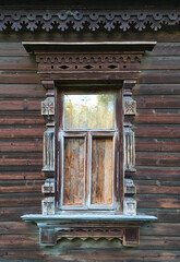 An old wooden window with a beautiful carved frame