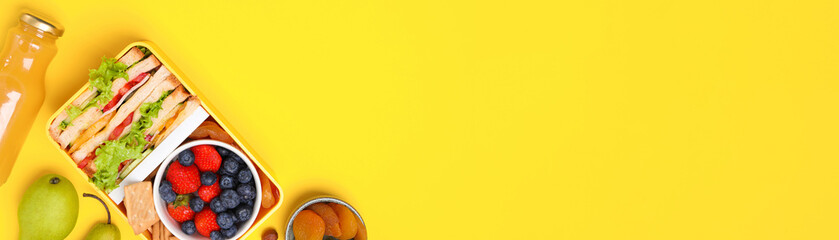 School meal. Flat lay composition with lunch box, tasty healthy food and juice on yellow...