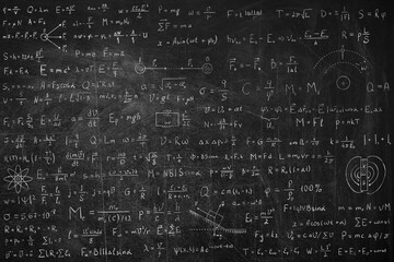 Many different physics formulas written on blackboard