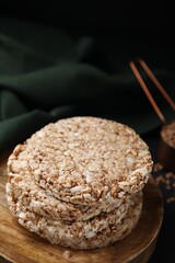 Stack of crunchy buckwheat cakes on wooden plate, closeup