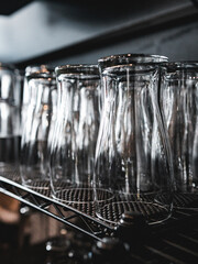 Elegant cristal reflective beer cups lined in a cup stand from a local modern and elegance business. Black faint background and clean areas. Beer cups ready to be fill from clients.