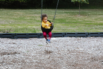 Young toddler having fun on swing