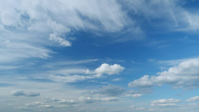 Soft white clouds moving on blue sky background. Tropical summer or spring sunlight. Daytime. Timelapse.