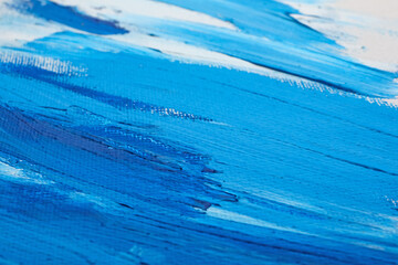 Beautiful strokes of blue oil paints on white canvas as background, closeup