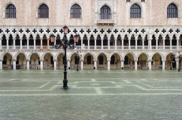 Piazzetta San Marco a Venezia invasa dall'acqua alta con un lampione e la facciata di Palazzo Ducale