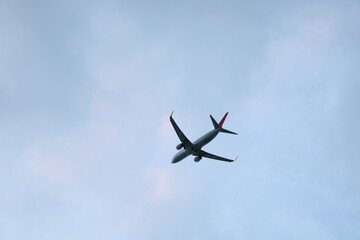 Modern white airplane flying in clear sky, low angle view