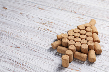 Christmas tree made of wine corks on white wooden table. Space for text