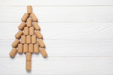 Christmas tree made of wine corks on white wooden table, top view. Space for text