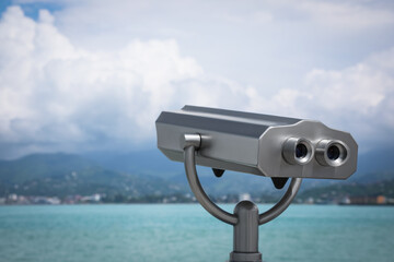 Metal tower viewer installed near sea, space for text. Mounted binoculars