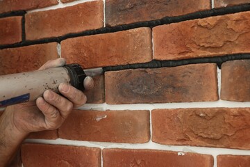 Professional builder using tiling fugue for grouting, closeup