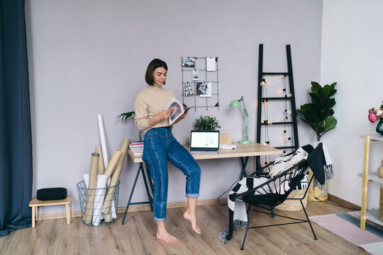 Woman Reading Magazine In Home Office